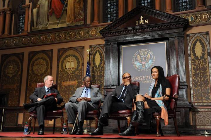Speakers seated on a stage in a Georgetown building.