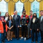Joe Biden and Kamala Harris standing in Oval Office with young, casually dressed labor activists