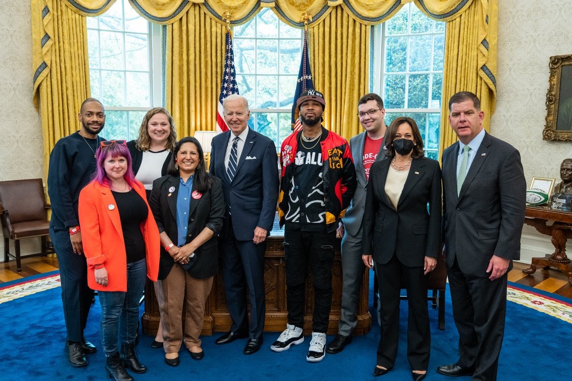 Joe Biden and Kamala Harris standing in Oval Office with young, casually dressed labor activists