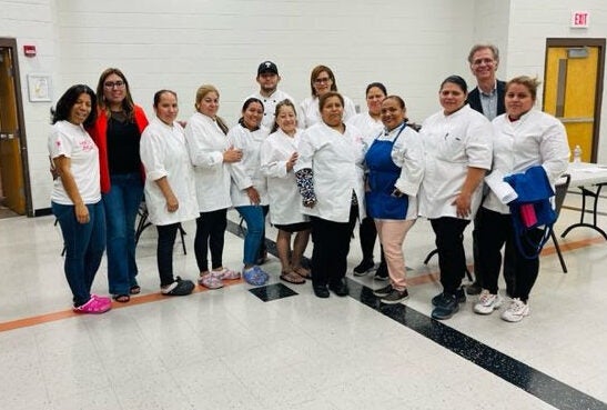 Group of restaurant workers stand in a line in open room